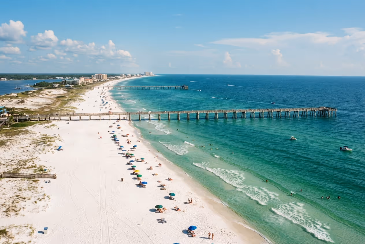 Faixa larga de areia branca de quartzo em Panama City Beach com o Golfo verde e o píer ao fundo