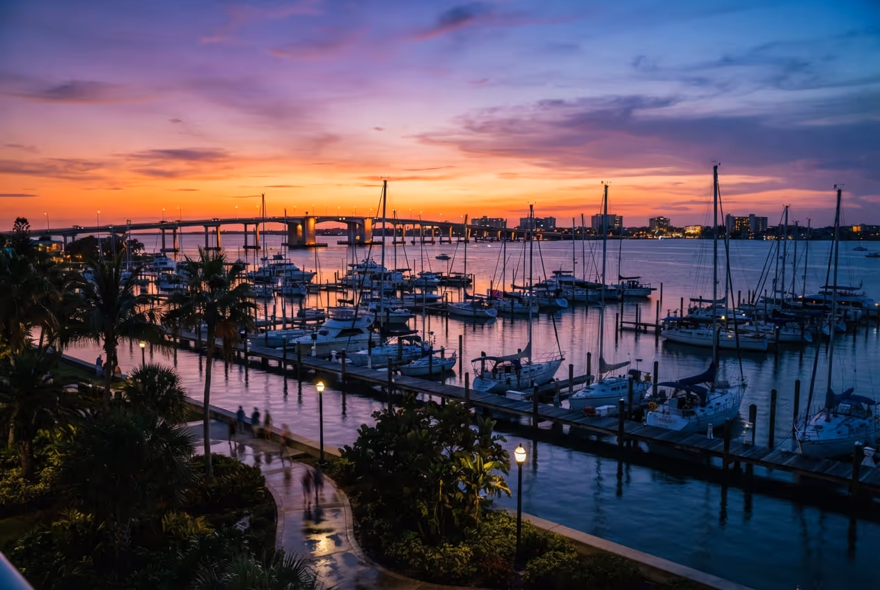 Baía de Sarasota ao entardecer com veleiros ancorados e a ponte para Lido Key ao fundo