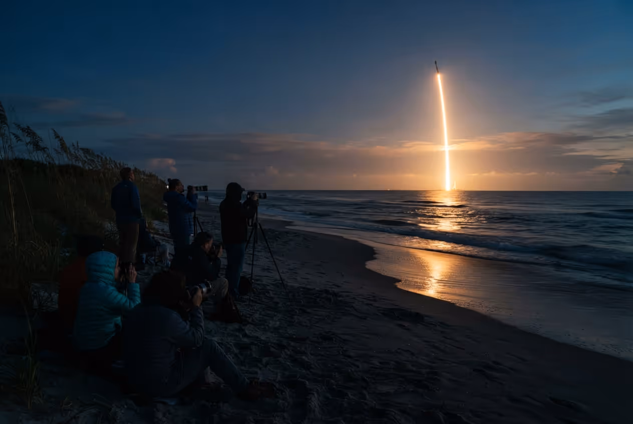 Rastro de fumaça de foguete subindo sobre o horizonte visto de uma praia da Space Coast ao entardecer